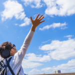 空に向かってバンザイする女性イメージ写真AC