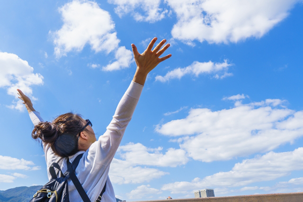 空に向かってバンザイする女性イメージ写真AC